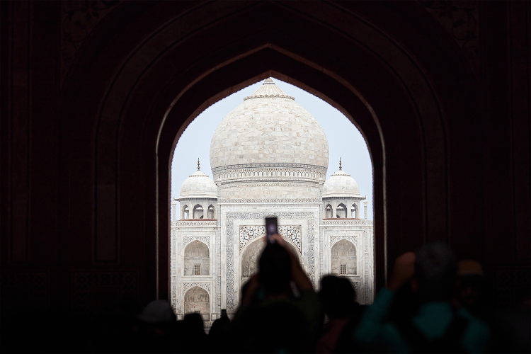 A tourist taking a photo of the Taj Mahal with their camera phone